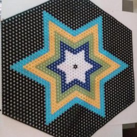 Multiple colour beaded star design in black background.